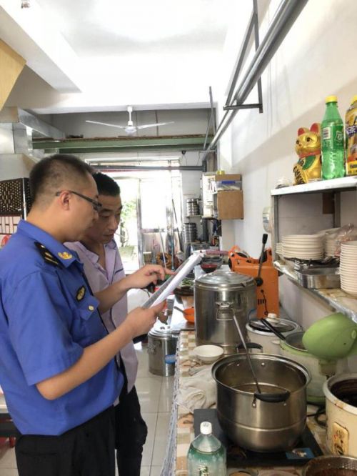 綜合執法人員對餐飲企業進行油煙污染檢查