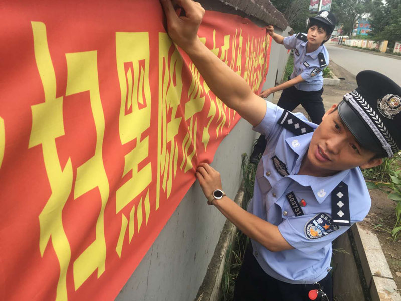 丹東市公安局振安分局同興派出所民警在懸掛掃黑除惡宣傳標(biāo)語(yǔ)橫幅。