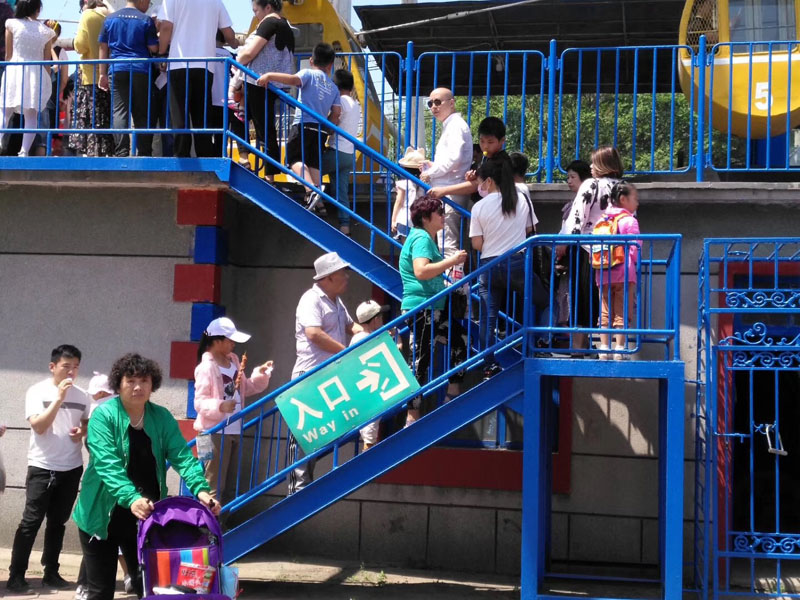 每年六一，陽陽（二樓緩步臺背書包女孩）都能在公園玩個痛快