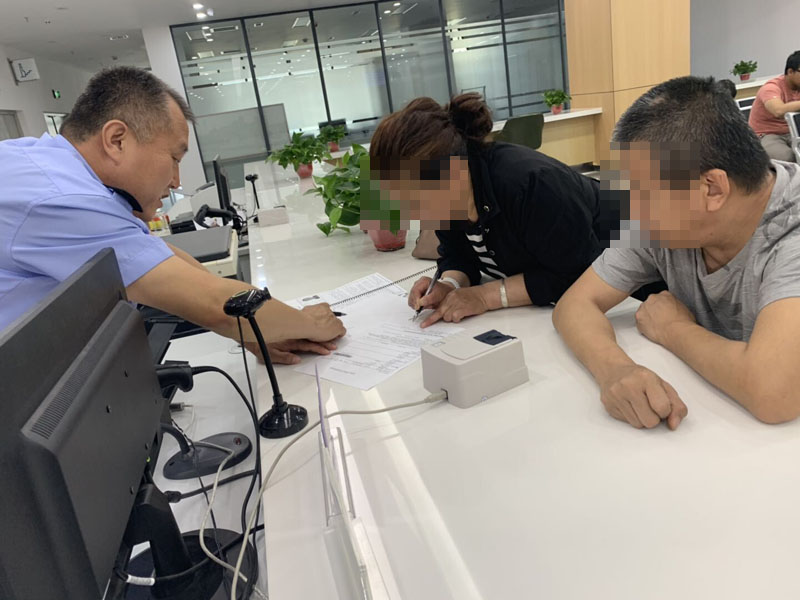 配文1：民警指導(dǎo)辦理護照的殘障人士手寫簽名