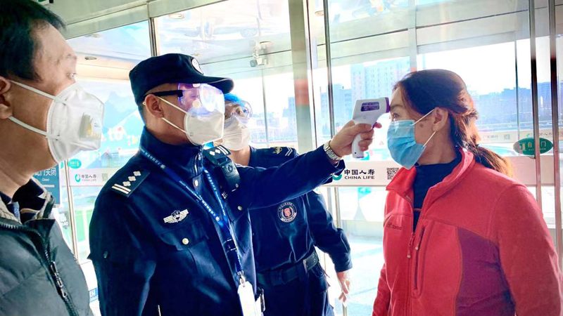 王鵬（左二）對旅客進行體溫檢測
