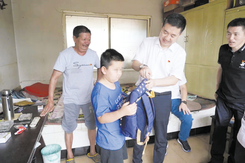 頭題配圖（擋孩子眼睛）為留守兒童贈送了書包及文具