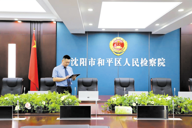 工作人員指尖輕觸功能鍵，“無紙化會議系統”進入啟動模式。