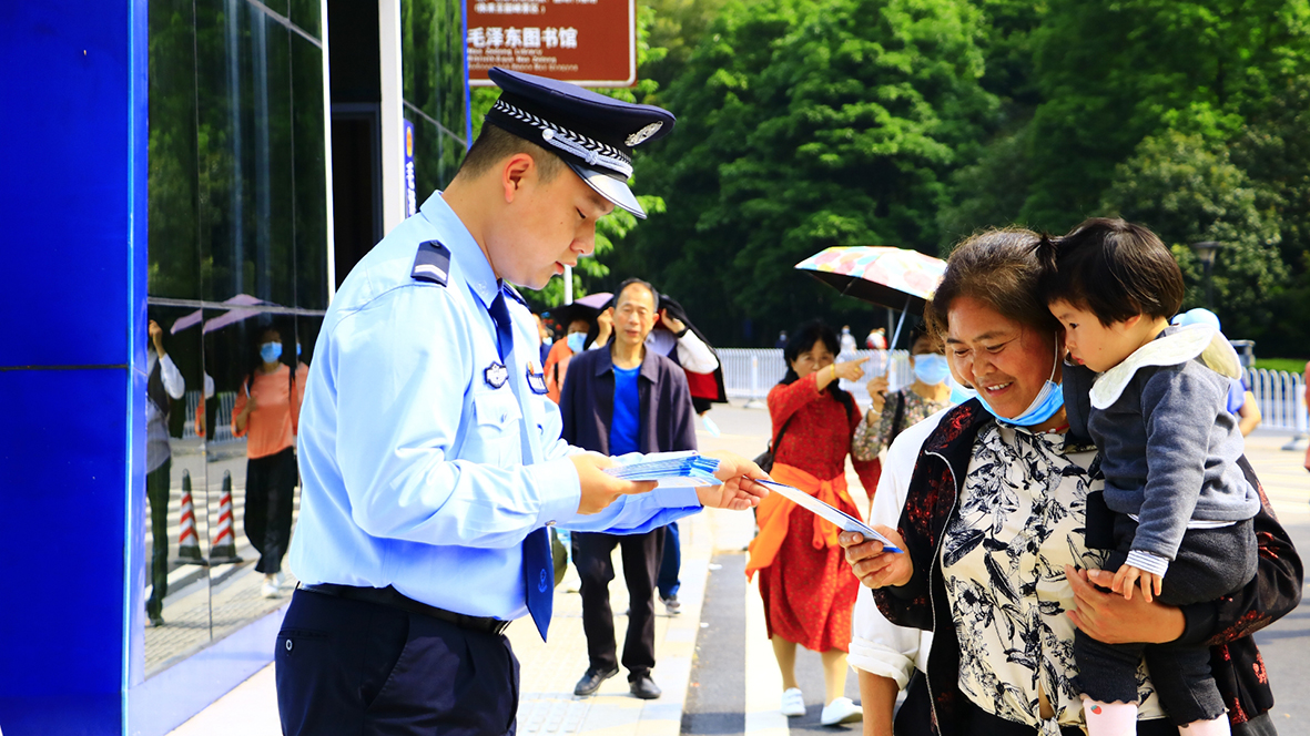 韶山沖派出所，民警向游客發放反詐宣傳單