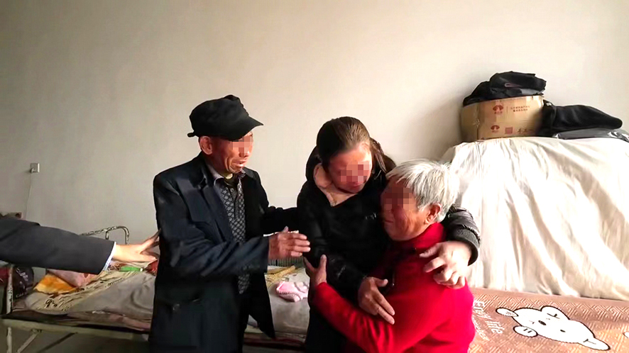 “肚兜女嬰”王麗（中）與父母團(tuán)圓。