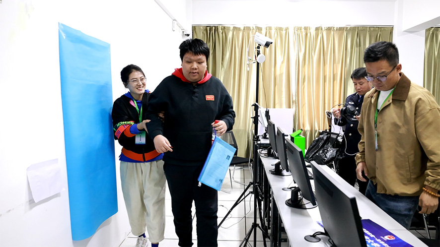 遼寧開放大學考區考務人員幫助盲人考生參加考試。
