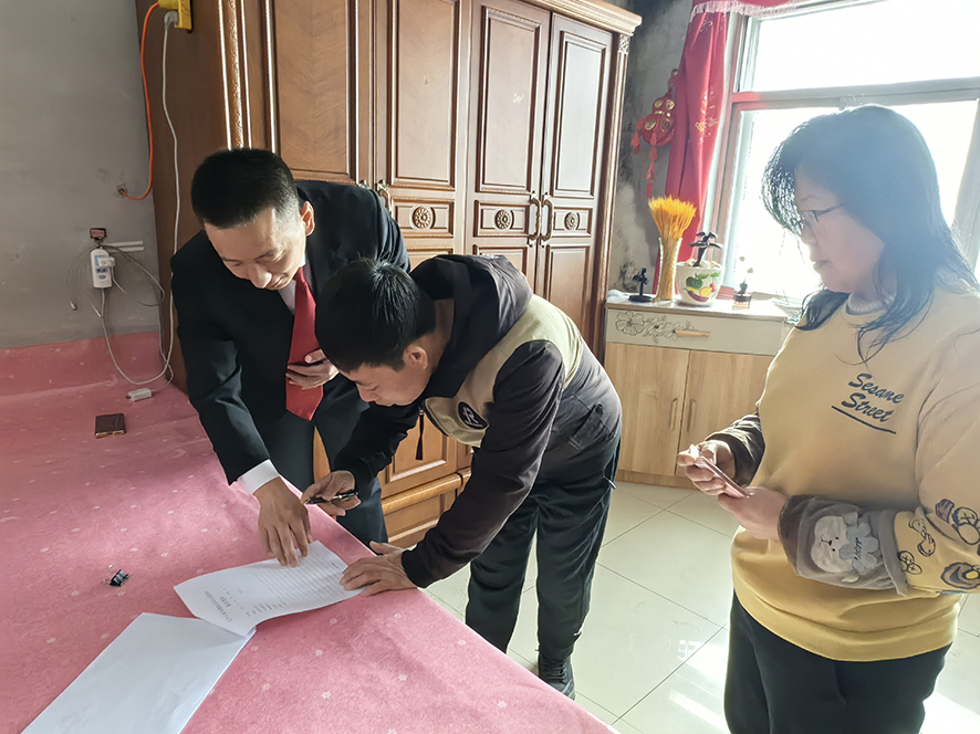 徐曉東（左一）指導孟某（中）在結(jié)案書上簽字