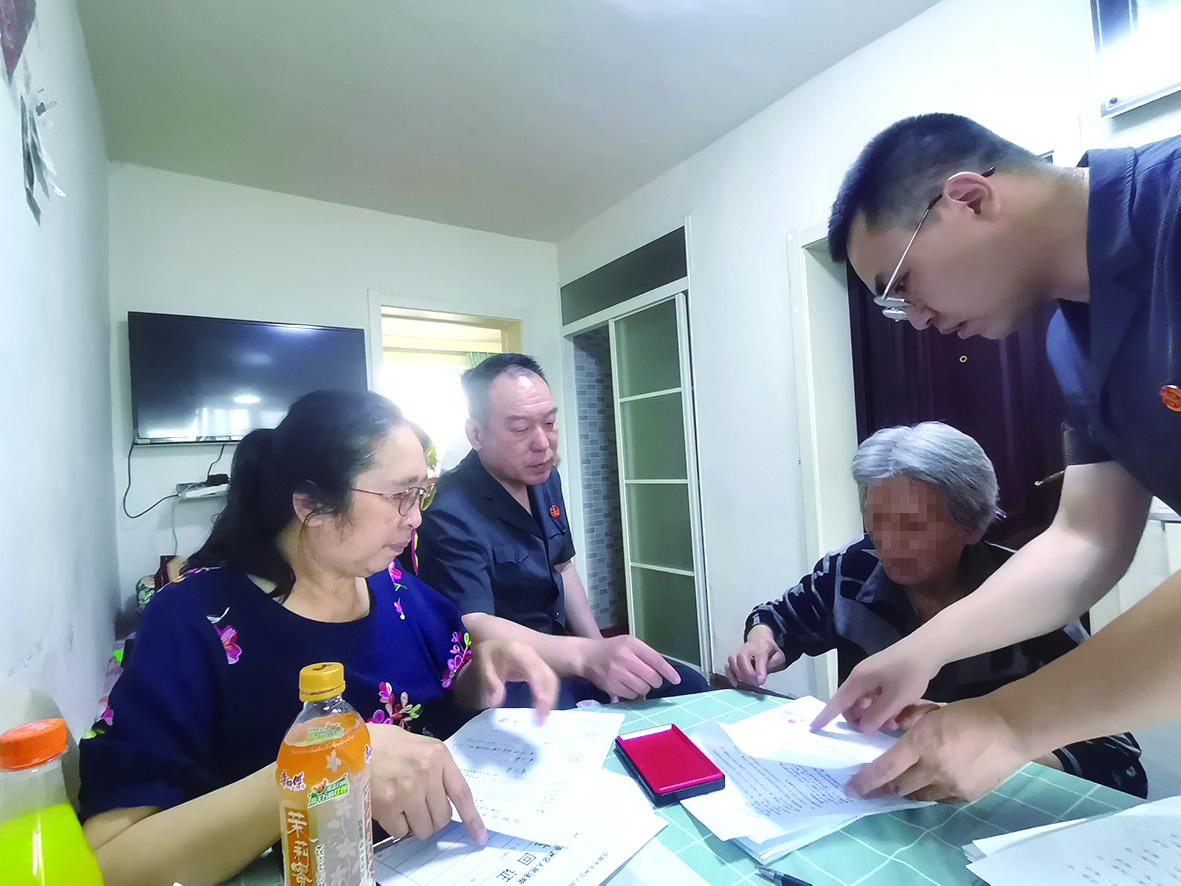 付承志（右一）胡善福（左二）指導潘某榮（右二）在調解書上簽字、按手印