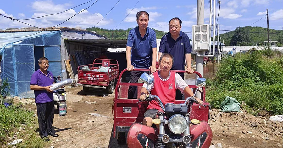 遼寧省食用菌協會副會長劉喜杰乘坐當地三輪車前往受災現場