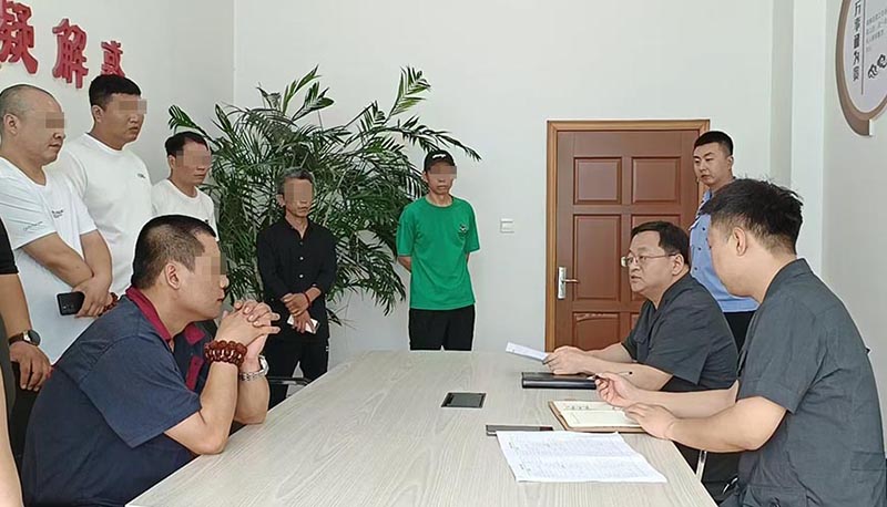 新民市法院執行局局長王旌棘（右3）向農民工們了解案情（所有不穿法服和警服的人，都需要馬賽克!）