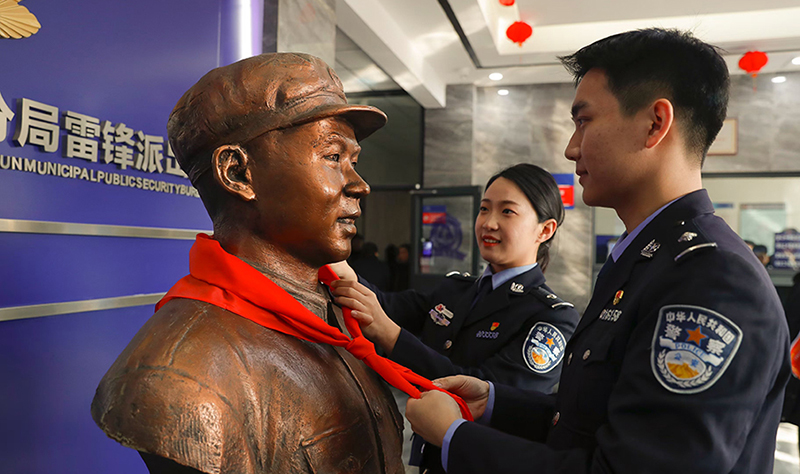 2024年3月5日，撫順市公安局望花分局雷鋒派出所民警白靜（右）和長沙市公安局雷鋒派出所民警韓政霖（左）共同為雷鋒塑像整理紅領巾。