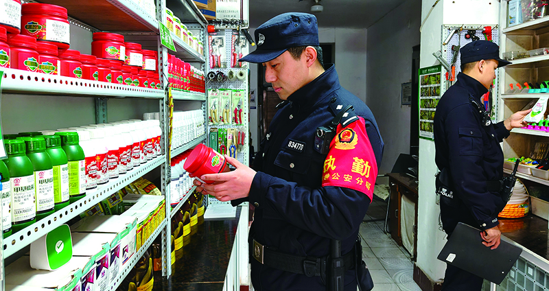 鐵嶺市公安局銅鐘分局治安民警在農資商店檢查核對農藥經營資質、質量、儲存、有效期等情況。